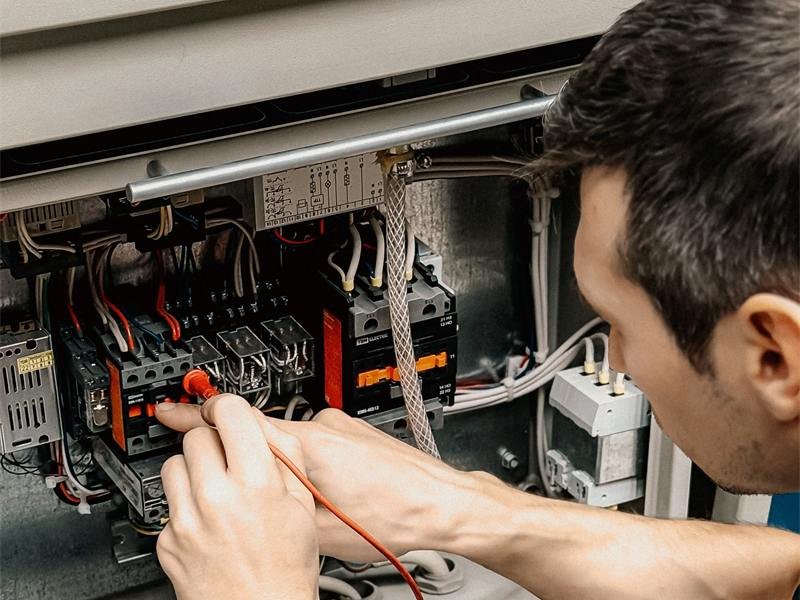 Električar mjeri spojeve u razvodnom ormaru
